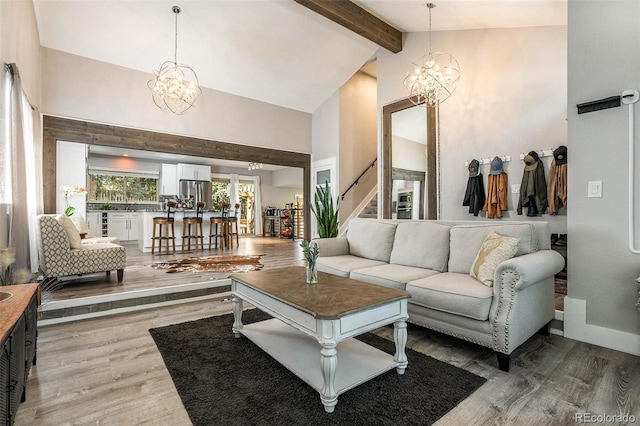 living room featuring beamed ceiling, high vaulted ceiling, a notable chandelier, and hardwood / wood-style flooring