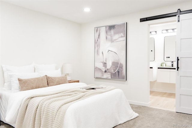 1361 W Custer Pl, Denver, CO 80223 - carpeted bedroom with a barn door, recessed lighting, and connected bathroom