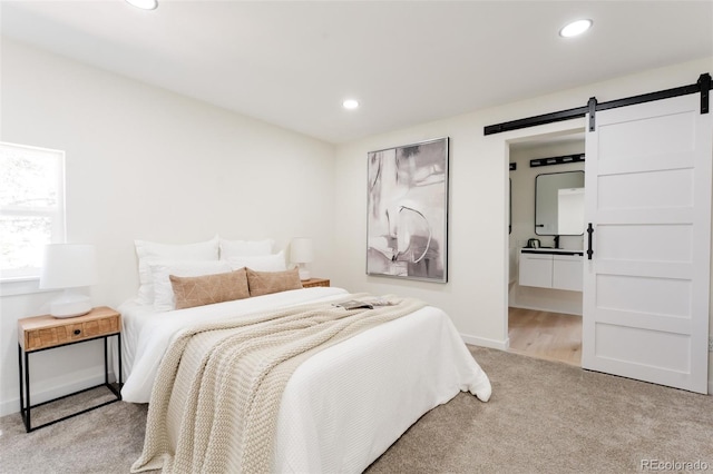 1361 W Custer Pl, Denver, CO 80223 - bedroom with a barn door, recessed lighting, carpet, and ensuite bath