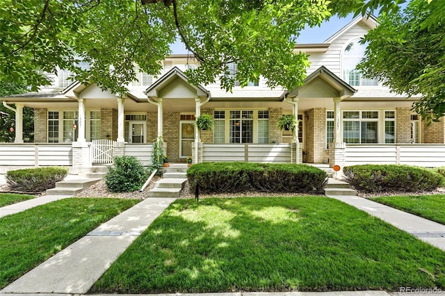 1325 W 112th Ave Unit B, Westminster, CO 80234 - view of front facade featuring brick siding, a front yard, and a porch