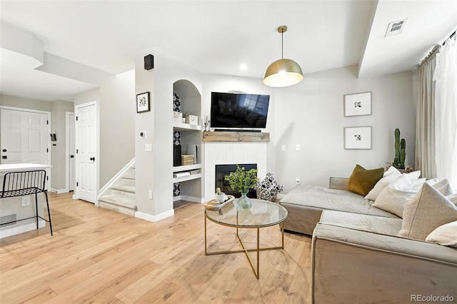 1325 W 112th Ave Unit B, Westminster, CO 80234 - living room with light wood-style floors, a glass covered fireplace, stairway, built in features, and recessed lighting