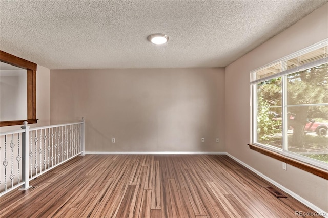3735 S Lewiston St, Aurora, CO 80013 - unfurnished room with wood finished floors, a textured ceiling, and healthy amount of natural light