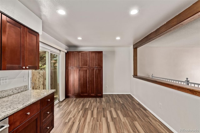 3735 S Lewiston St, Aurora, CO 80013 - kitchen featuring wood finished floors, recessed lighting, light stone counters, and dark brown cabinets