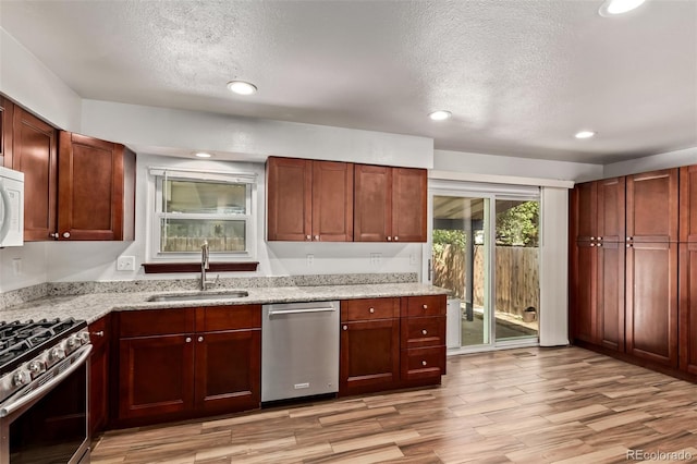 3735 S Lewiston St, Aurora, CO 80013 - kitchen with stainless steel appliances, a textured ceiling, light wood-style floors, light stone countertops, and recessed lighting