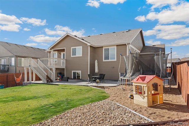 back of house with a patio area, a yard, a trampoline, and a wooden deck