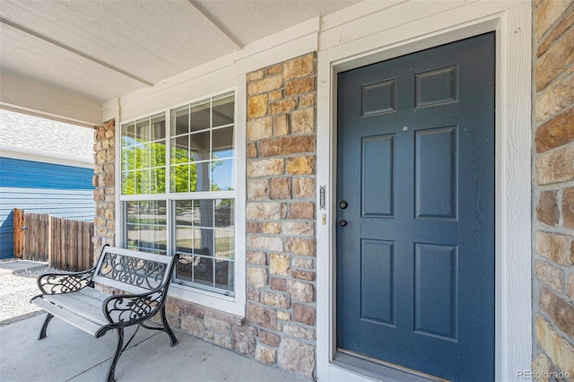 6833 E 115th Ave, Thornton, CO 80233 - doorway to property featuring covered porch and stone siding