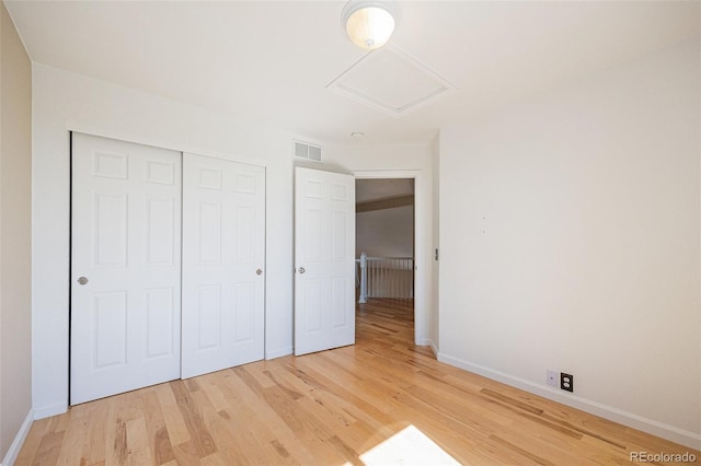 6833 E 115th Ave, Thornton, CO 80233 - unfurnished bedroom featuring attic access, light wood-style floors, and a closet