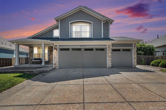 6833 E 115th Ave, Thornton, CO 80233 - traditional home with covered porch, driveway, stone siding, and a garage