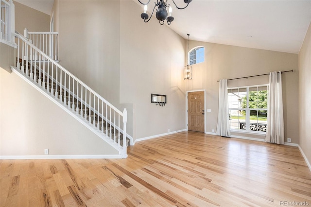 6833 E 115th Ave, Thornton, CO 80233 - foyer with high vaulted ceiling, a chandelier, wood finished floors, and stairs