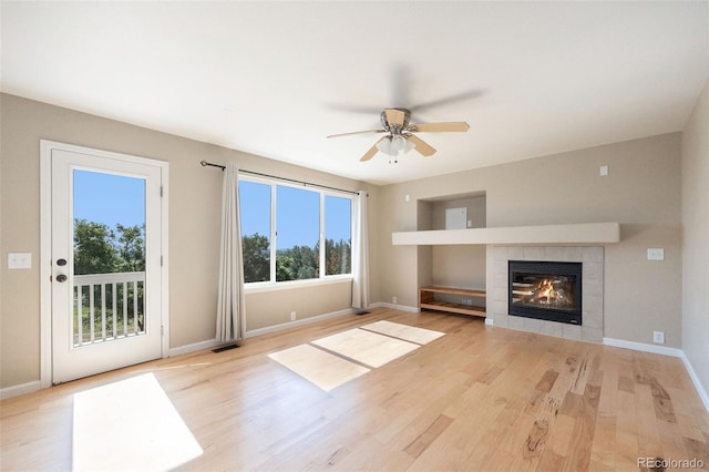 6833 E 115th Ave, Thornton, CO 80233 - unfurnished living room with a ceiling fan, a fireplace, and wood finished floors