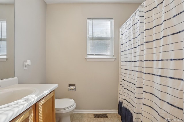 bathroom featuring tile patterned flooring, vanity, and toilet