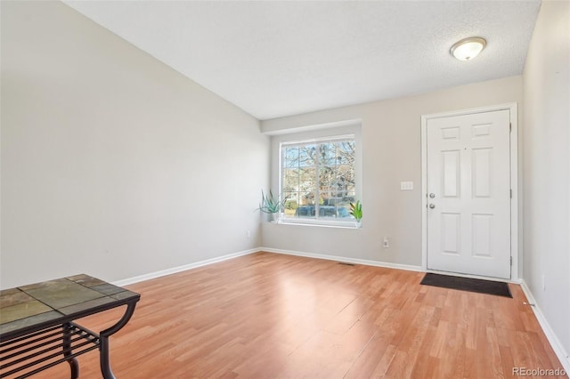 entrance foyer featuring a textured ceiling and light hardwood / wood-style flooring