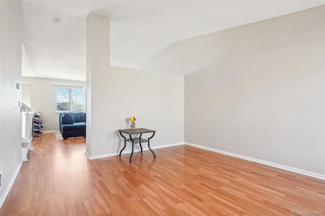 empty room with lofted ceiling and light hardwood / wood-style floors