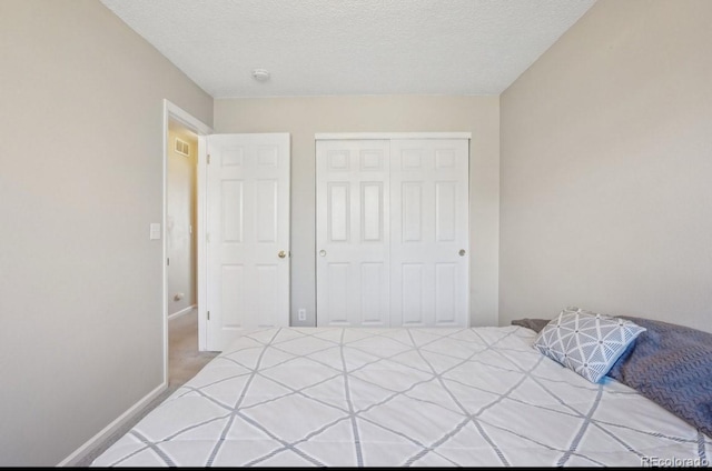 bedroom with a closet and a textured ceiling