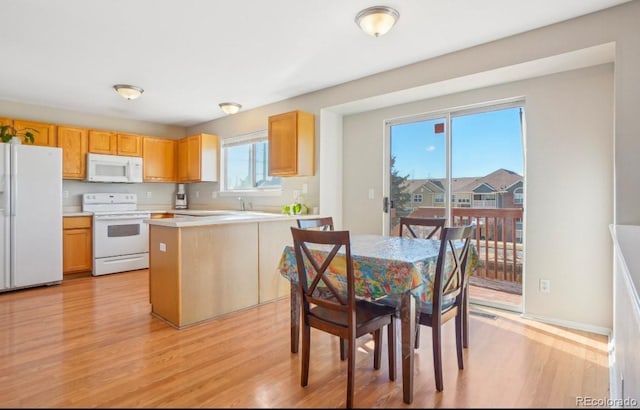 kitchen featuring a kitchen island, white appliances, and light hardwood / wood-style flooring