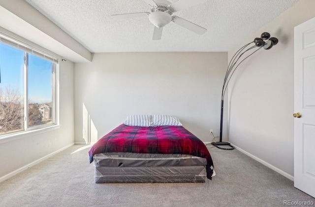 bedroom featuring ceiling fan, carpet, and a textured ceiling