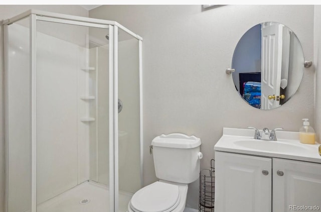 bathroom with vanity, an enclosed shower, and toilet