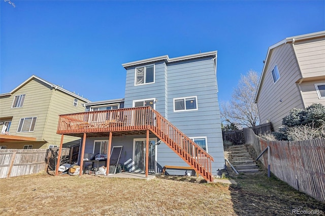 back of house with a lawn and a deck