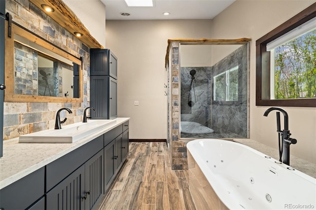 10380 W Warren Ave, Lakewood, CO 80227 - bathroom featuring a whirlpool tub, tiled shower, vanity, wood finished floors, and decorative backsplash