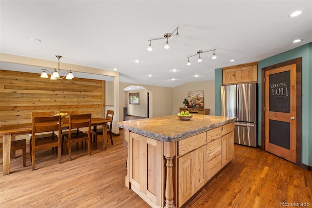 10380 W Warren Ave, Lakewood, CO 80227 - kitchen with freestanding refrigerator, arched walkways, light wood-type flooring, a kitchen island, and recessed lighting