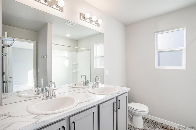 bathroom with tile patterned floors, vanity, toilet, and walk in shower