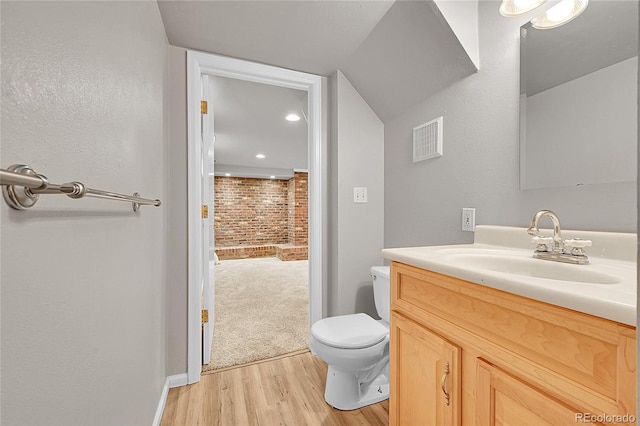 1030 Kohl St, Broomfield, CO 80020 - bathroom with wood finished floors, vanity, brick wall, and recessed lighting