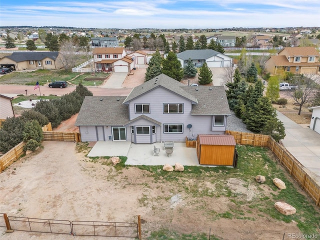 11640 Cranston Dr, Peyton, CO 80831 - rear view of house featuring roof with shingles, a patio area, an outdoor structure, a residential view, and a fenced backyard