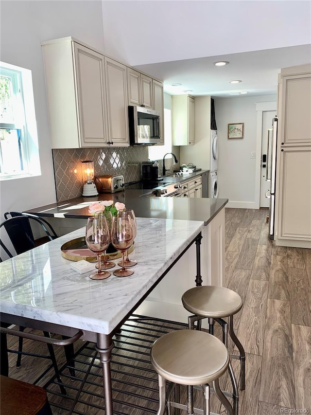 47 Lumberjack Rd, Fairplay, CO 80440 - kitchen featuring stainless steel microwave, estacked washer and dryer, a peninsula, tasteful backsplash, and recessed lighting