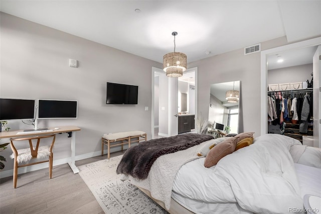 bedroom featuring a spacious closet, light wood-type flooring, and a closet