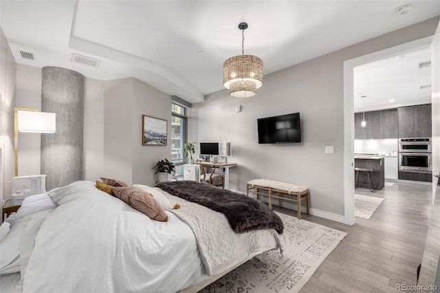 bedroom featuring a chandelier and light hardwood / wood-style floors