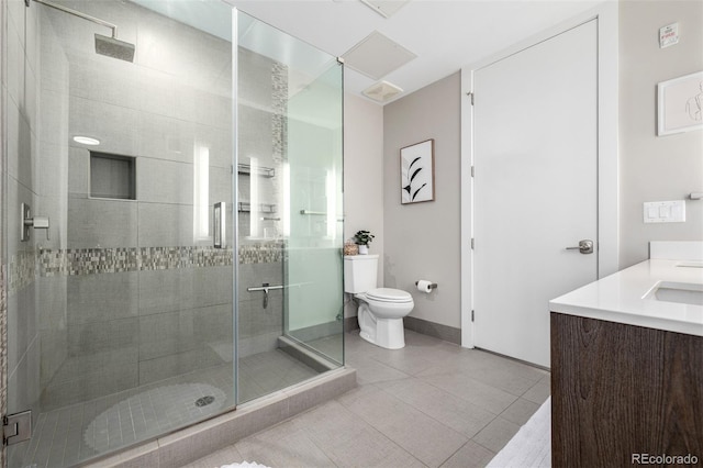 bathroom featuring vanity, toilet, tile patterned flooring, and a shower with door