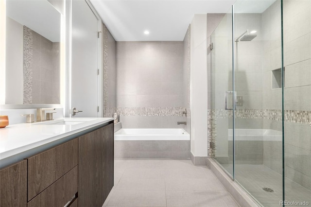 bathroom with tile patterned flooring, vanity, and separate shower and tub