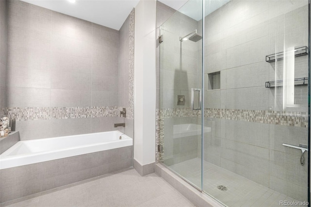 bathroom featuring tile patterned flooring and shower with separate bathtub