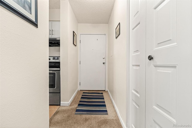 interior space with a textured ceiling and light carpet