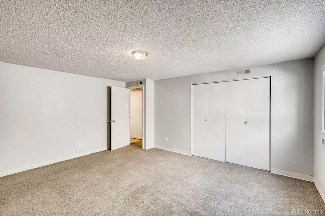 141 Mcclure Ave, Firestone, CO 80520 - unfurnished bedroom featuring carpet, a closet, baseboards, and a textured ceiling