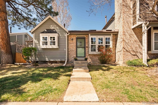 view of front of house featuring brick siding and a front lawn