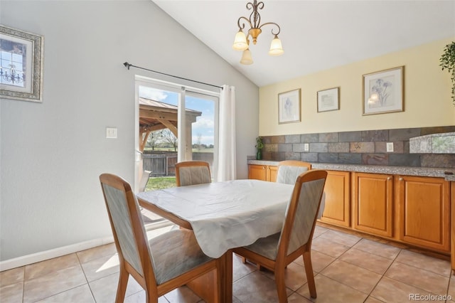 dining space with light tile patterned flooring, baseboards, a chandelier, and vaulted ceiling