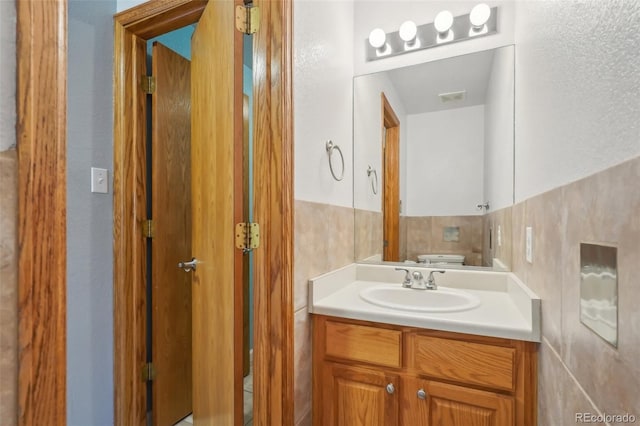 half bath with toilet, visible vents, and vanity