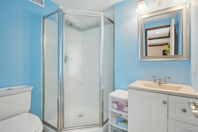 full bath with toilet, visible vents, a shower stall, and vanity