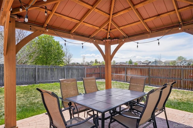 view of patio featuring a gazebo, outdoor dining area, and a fenced backyard