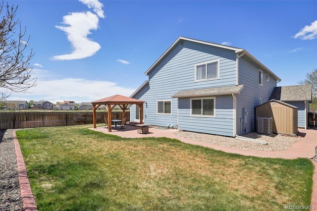 back of property featuring a fenced backyard, a storage unit, a patio, and a gazebo