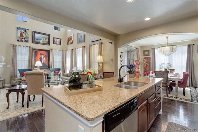 9546 Firenze Way, Highlands Ranch, CO 80126 - kitchen featuring dishwasher, a sink, arched walkways, open floor plan, and light stone counters