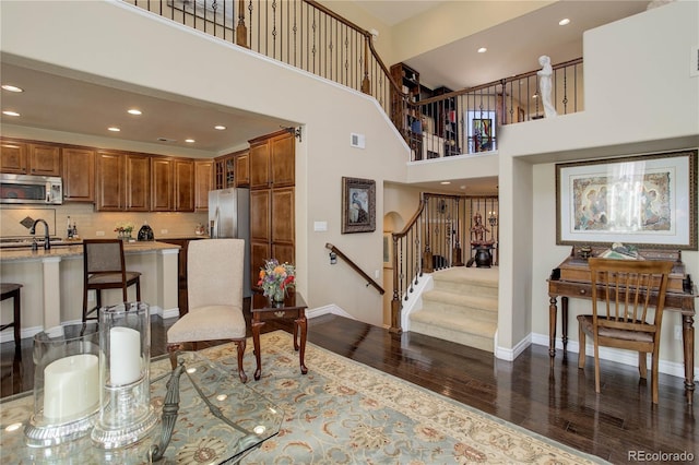 9546 Firenze Way, Highlands Ranch, CO 80126 - living room with dark wood-style flooring, baseboards, recessed lighting, stairs, and a high ceiling