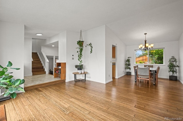 interior space featuring an inviting chandelier, baseboards, light wood-type flooring, and stairs