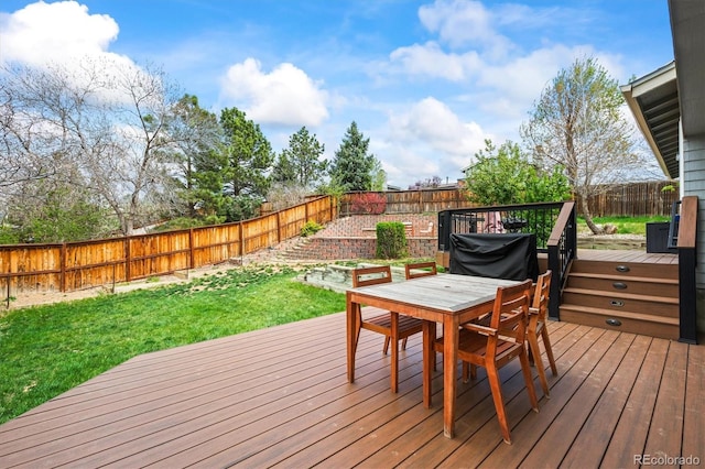 wooden deck featuring a yard, a fenced backyard, and outdoor dining space