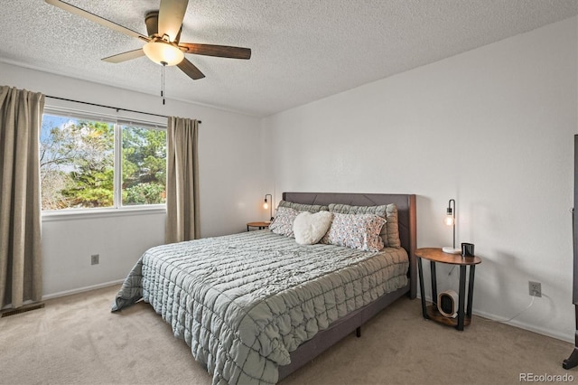 bedroom with carpet floors, a textured ceiling, ceiling fan, and baseboards