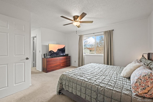 bedroom with carpet, a ceiling fan, and a textured ceiling