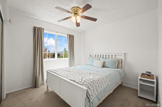 carpeted bedroom with baseboards, a ceiling fan, and a textured ceiling