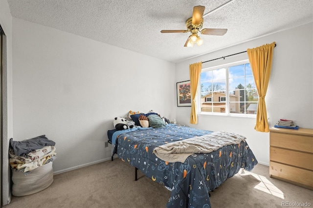 bedroom with carpet floors, a ceiling fan, a textured ceiling, and baseboards