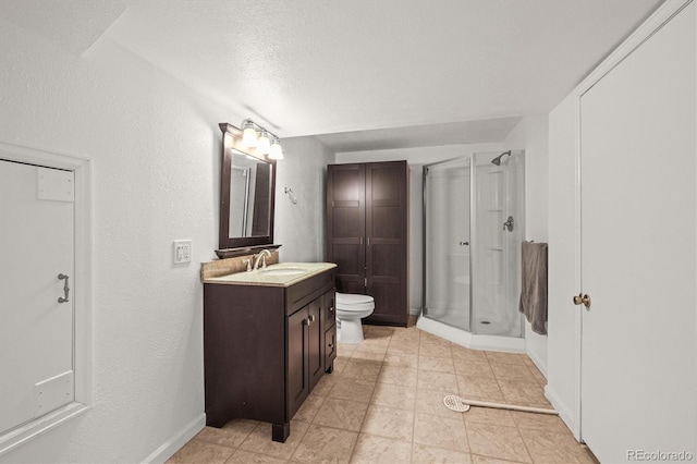 full bathroom with a textured wall, vanity, toilet, baseboards, and a stall shower